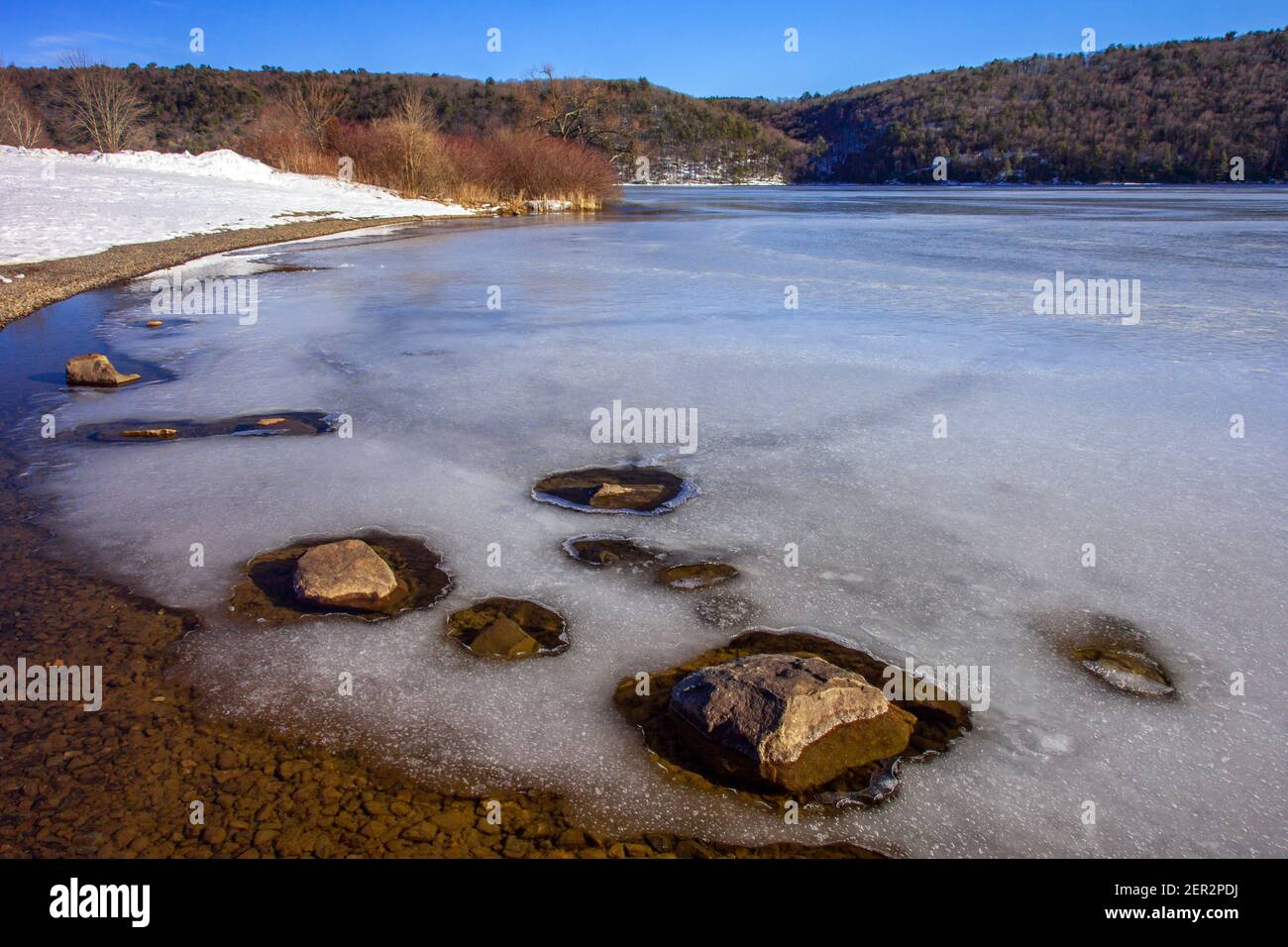 Eine späte Wintersonne erzeugt Sonnenerwärmung verursacht Schnee und Eis schmelzen entlang dem Ufer des Beltzville Lake in Carbon County, Pennsylvania Stockfoto