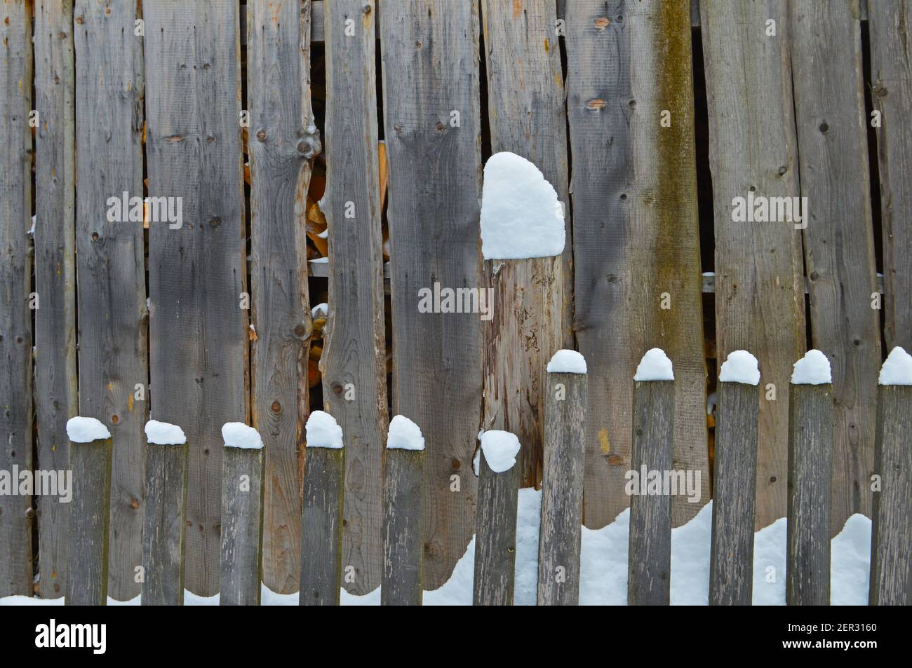 Holzzaun mit losem Neuschnee bedeckt Stockfoto