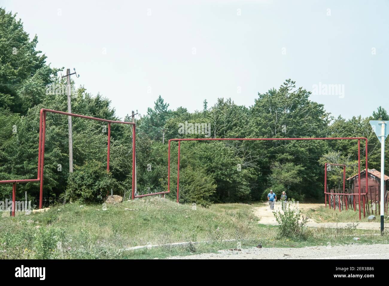 7-21-2019 Sachkhere Region Georgien - erhöhte Gasleitungen, die laufen Durch die Dörfer von Georgien und über Straßen - lokal Ein Paar läuft an einer Seitenstraße entlang Stockfoto