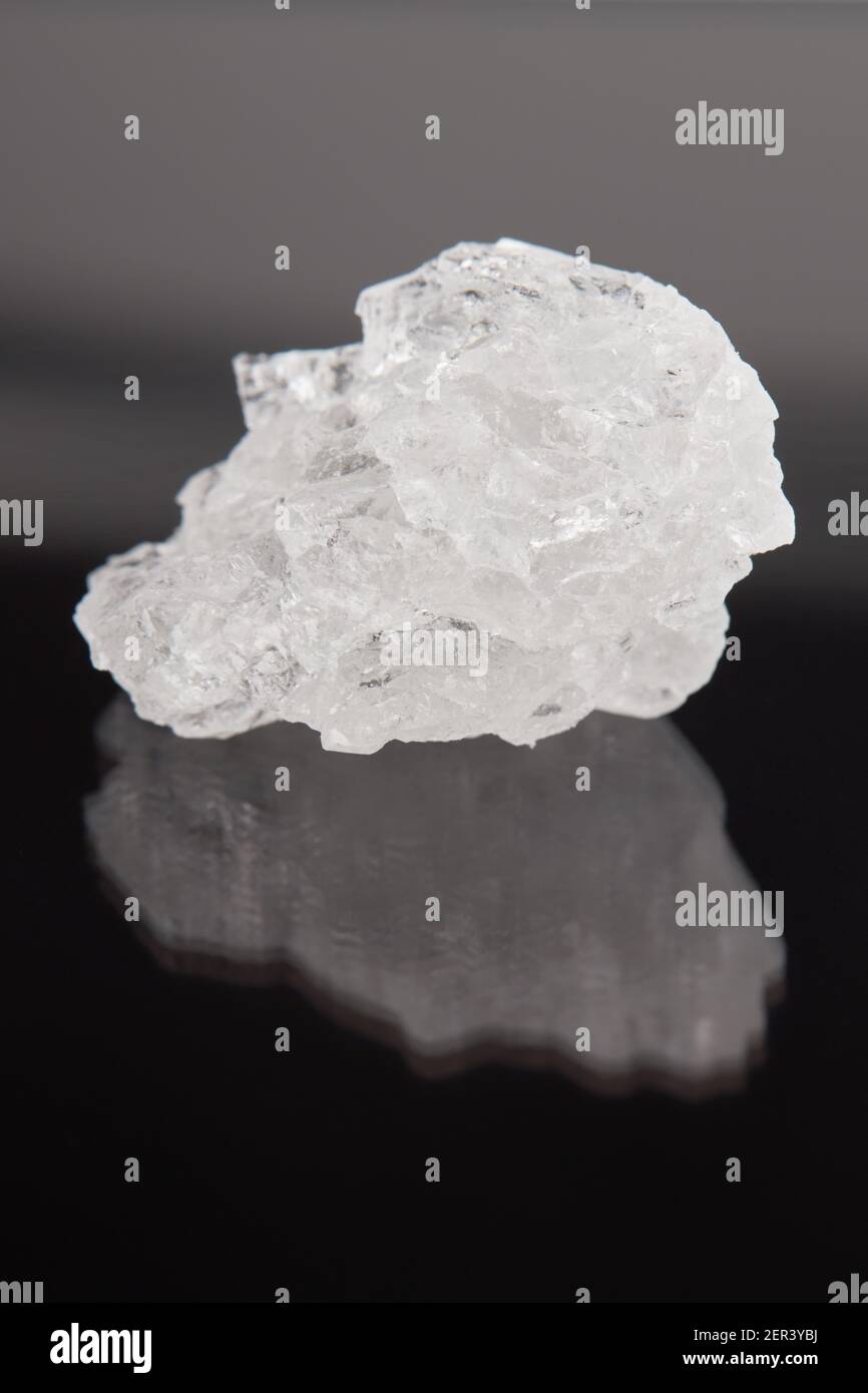 Bergsalzkristall über dunklem Hintergrund. Weltraum. Vertikale Ausrichtung Stockfoto