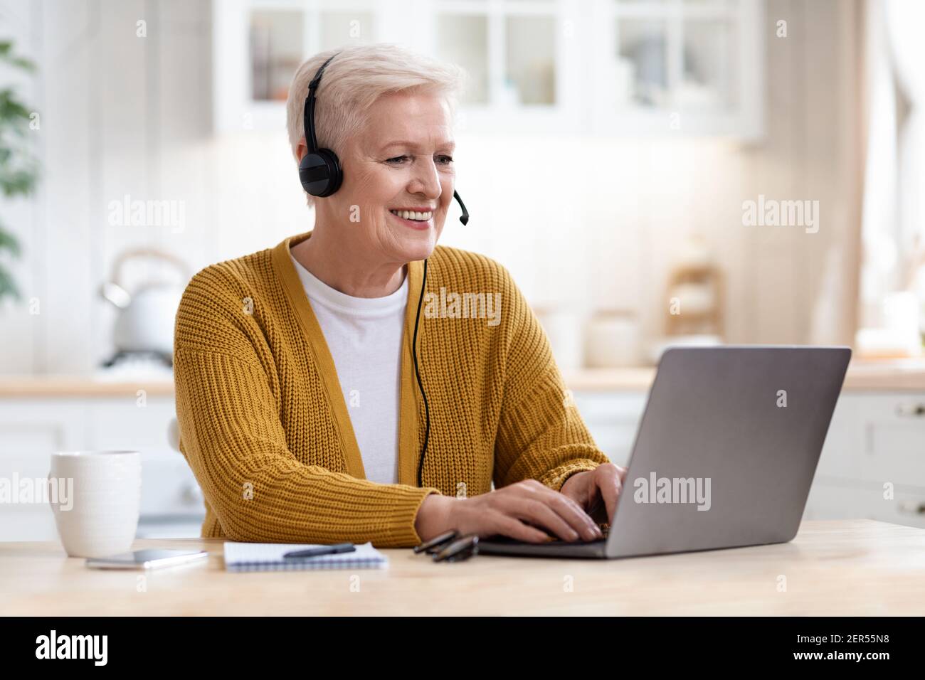 Glückliche alte Frau mit Laptop, mit Videokonferenz Stockfoto