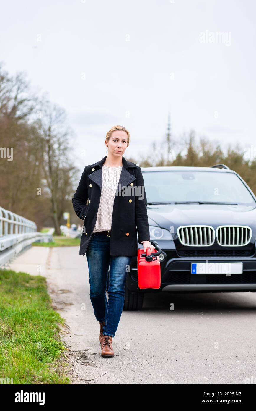 Die Frau hatte nicht mehr Kraftstoff, das Auto begann auf die nächste zu laufen Tankstelle Stockfoto