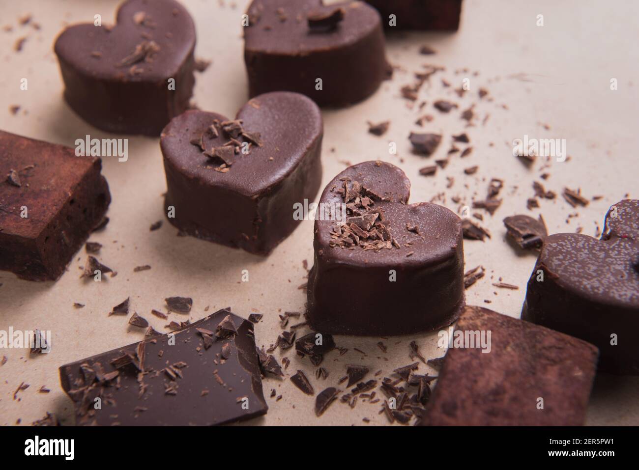 Zwei handgemachte Schokoladenherzen auf handwerklichen Hintergrund mit Chips. Valentine s Konzept Stockfoto