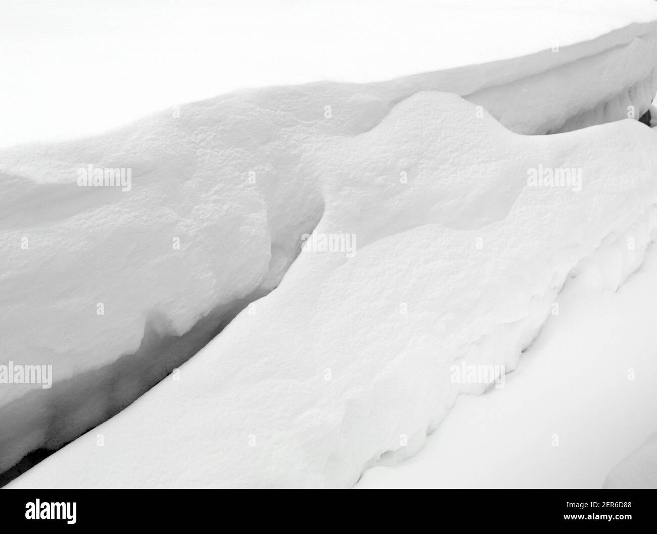 Schneeverwehung. Tiefschnee driftet im Winter. Schneeverwehung, geformt von starkem Winterschneeszard. Stockfoto