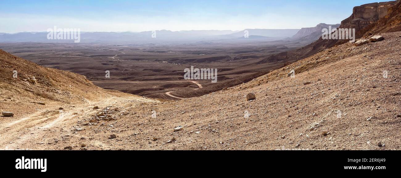 Jeep Road den Noah Ascent hinunter in den Makhtesch Ramon Krater in Israel mit Blick nach Südwesten mit Klippen und Bergen in Der Hintergrund und karge Deser Stockfoto