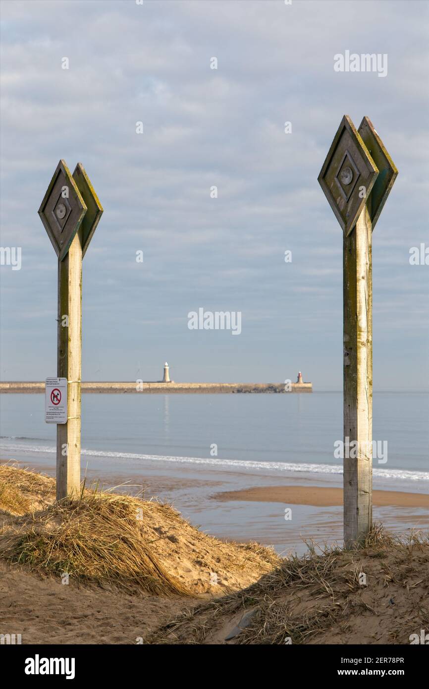 Zwei Pfosten markieren den Eingang zum Strand in der Nähe von Trow Point bei South Shields, South Tyneside schön umrahmt die Piers und Leuchttürme an der Mündung von Stockfoto