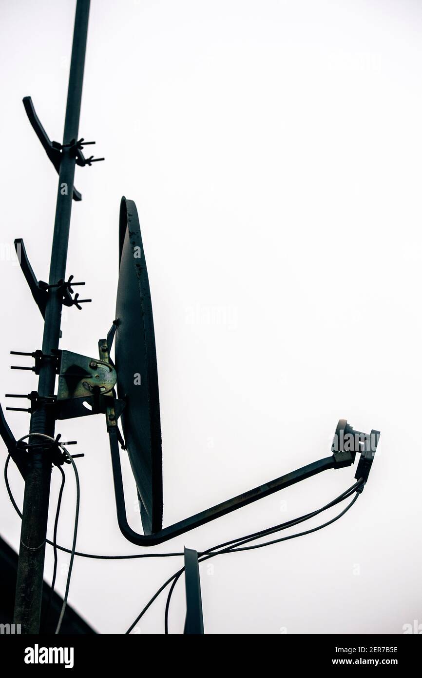 Silhouette einer Satellitenschüssel auf dem Dach eines Haus Stockfoto