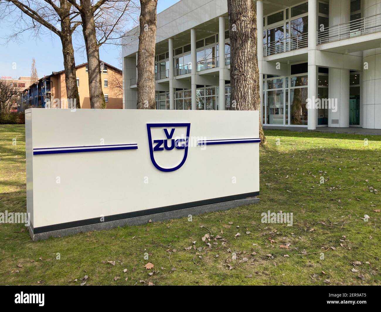 Zug, Schweiz - 26th. Februar 2021 : Firmenzeichen der V-Zug AG vor dem ZUGORAMA-Gebäude in Zug, Schweiz. V-Zug ist Schweizer Hersteller von ho Stockfoto