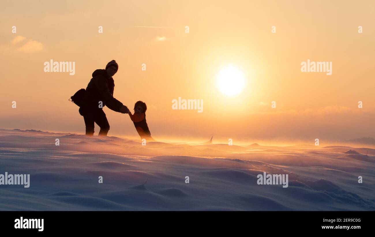Winterwunderland - Spaß für Mensch und Hund - Magische Atmosphäre mit buntem, weichem Nebel, der das Schneefeld bedeckt Stockfoto