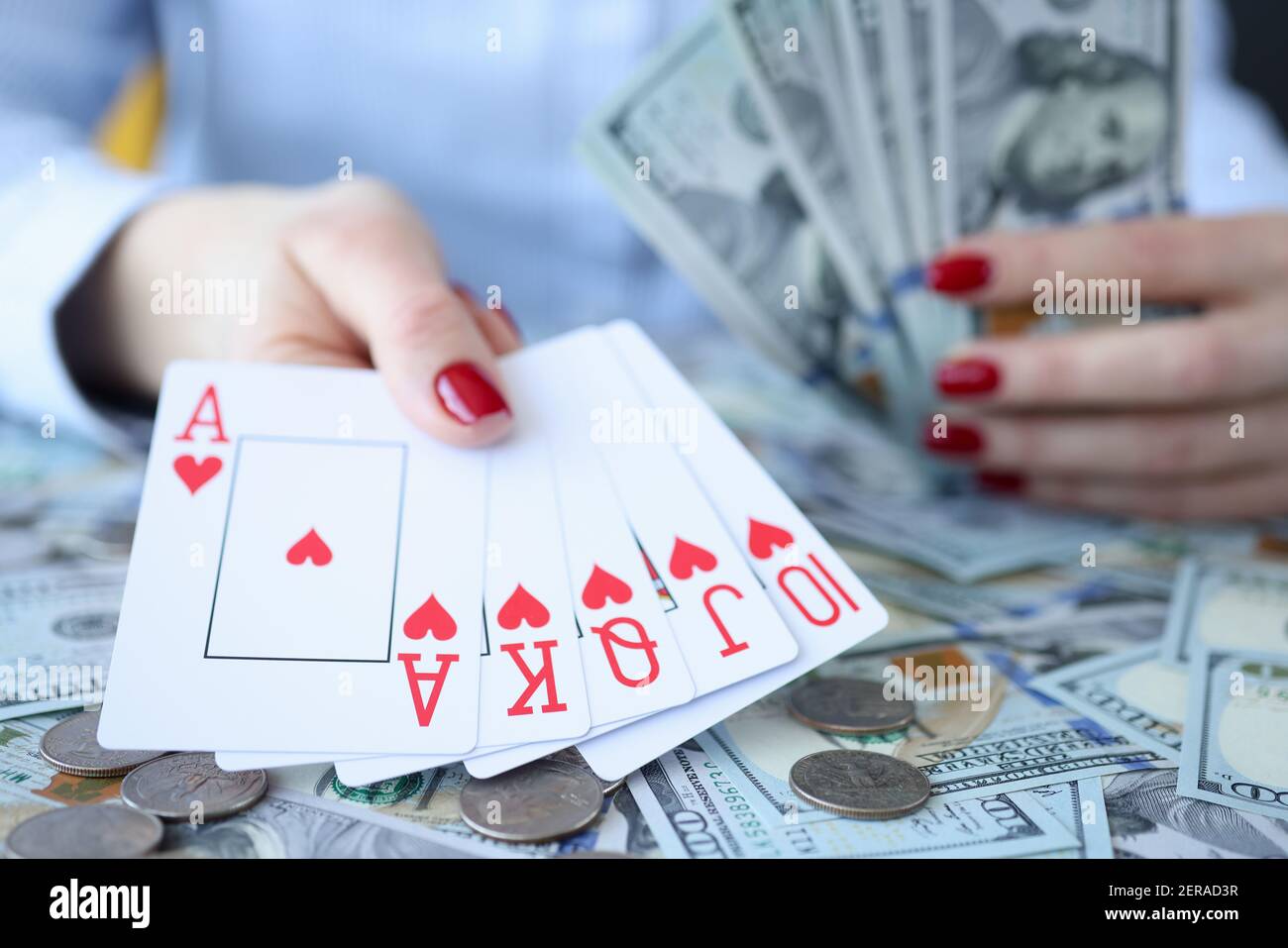 Frau hält Dollarscheine und spielt Karten in ihren Händen Stockfoto