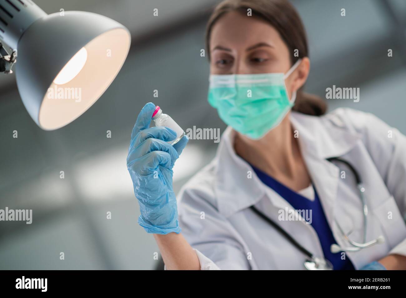 In der medizinischen Klinik hat die Impfung der Bevölkerung gegen covid-19 begonnen, der Arzt zeigt eine Flasche mit dem Impfstoff Stockfoto