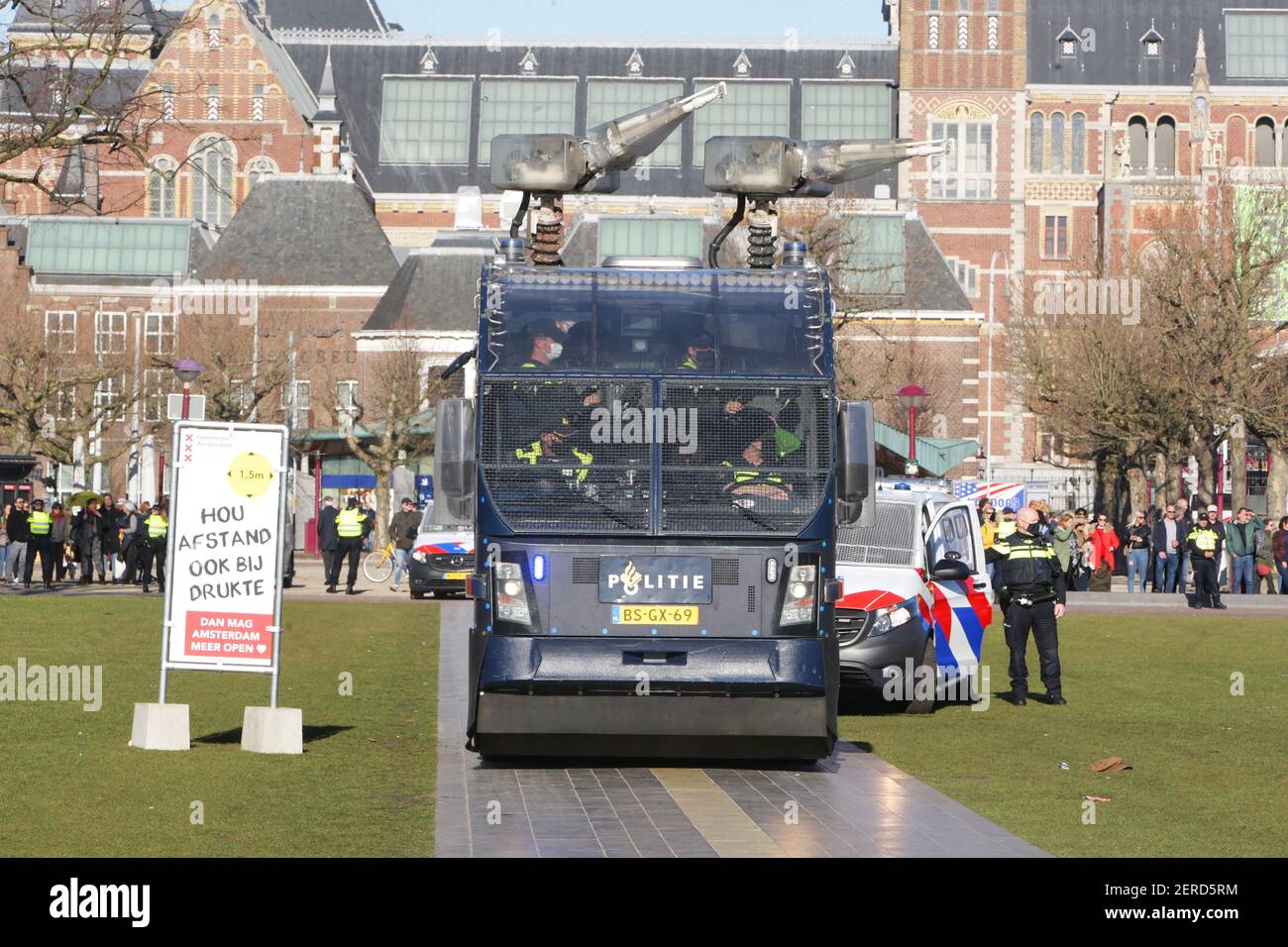Niederländische Anti-Riot-Polizisten Wasser Kanone Fahrzeug Team Position nehmen In der Nähe Anti-Lockdown-Anhänger während der illegalen Demonstration gegen die Coronav Stockfoto