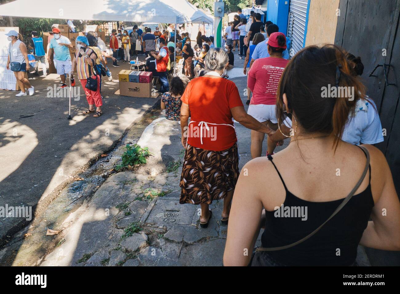 Mejicanos, San Salvador, El Salvador. 28th. Februar 2021. Mehrere Menschen stehen Schlange, um in eines der Wahlzentren in der Gemeinde Mejicanos in San Salvador einzutreten. An diesem Tag finden Parlaments- und Kommunalwahlen statt, bei denen neue Vertreter und Bürgermeister gewählt werden, was eine der wichtigsten Wahlen für das Land ist. Kredit: Carlos Diaz/Alamy Live Nachrichten. Stockfoto