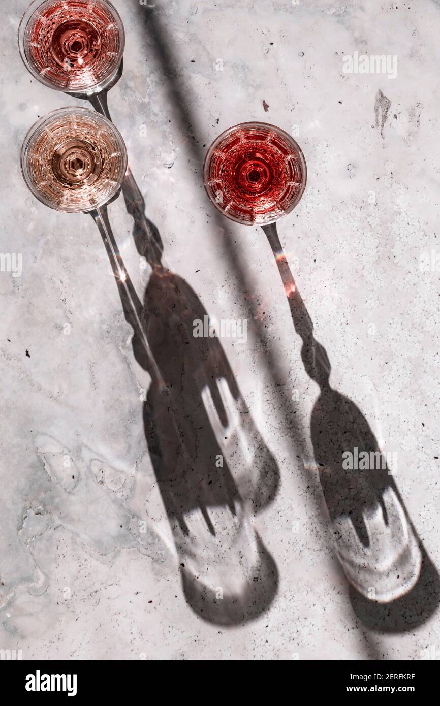 Drei Roséweine´ Gläsern, die harte Schatten werfen. Stockfoto