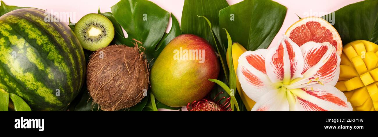 Kreative flach mit tropischen Früchten und Pflanzen auf rosa Hintergrund Stockfoto