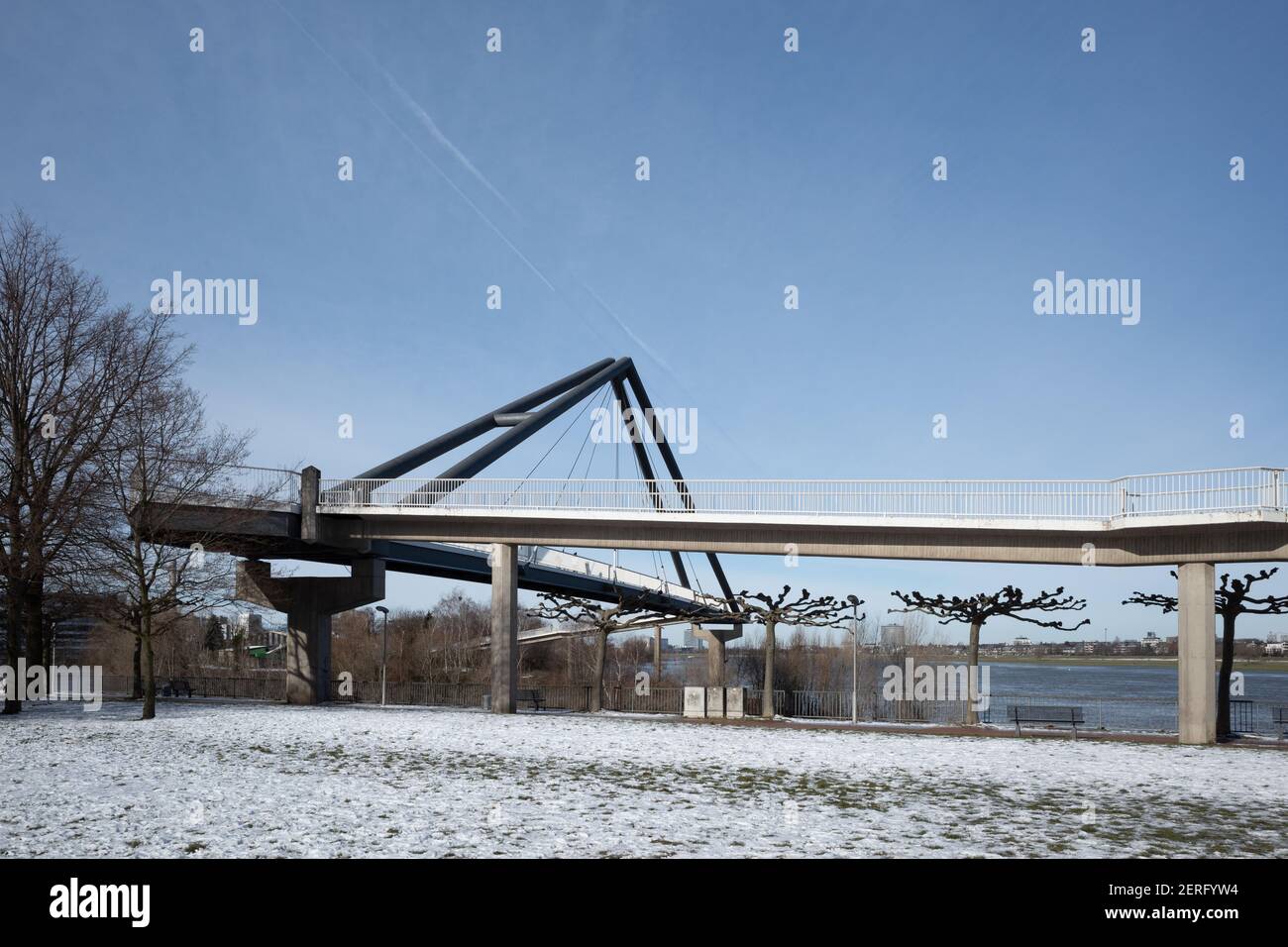 Sonnige Außenansicht der Fussgängerbrücke, Fußgängerbrücke, Rheinpark Bilk und schneebedecktes Feld an der Rheinpromenade in der Wintersaison. Stockfoto