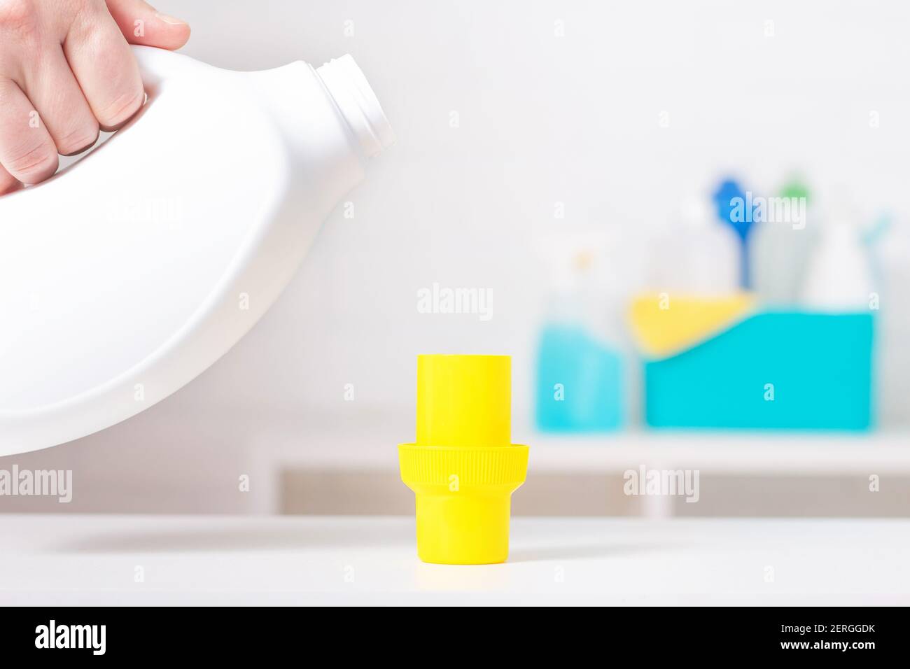 Weiße Chlor-Flasche mit gelbem Deckel Mock-up. Giftiges Reinigungsmittel.  Reinigungszubehör im Hintergrund. Verwendung des Messbechers  Stockfotografie - Alamy