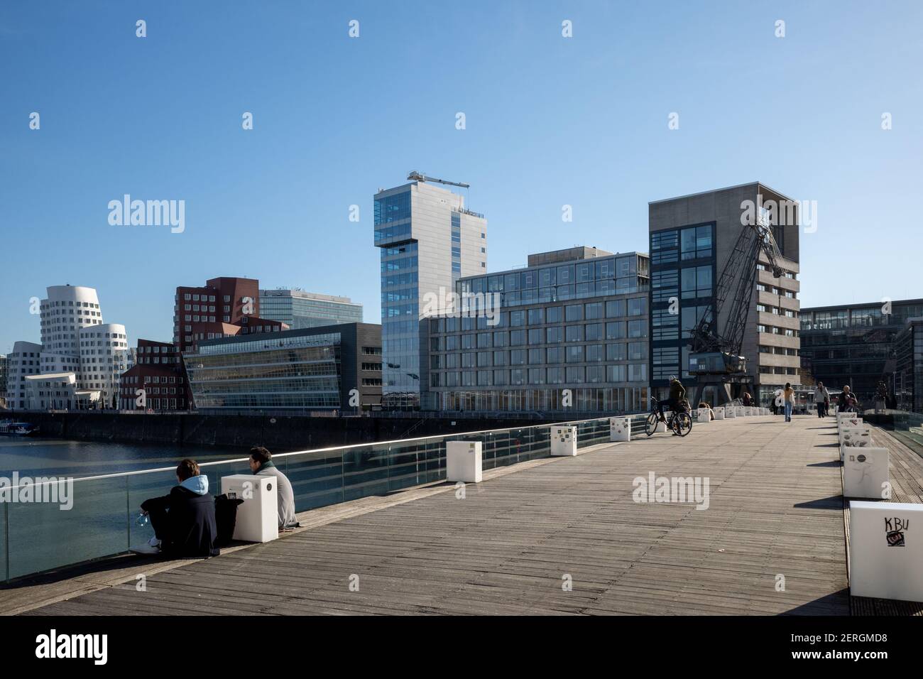 Sonnige Außenlandschaft auf der Brücke im Medienhafen, Fußgängerbrücke, am Medienhafen und Hintergrund des von Frank Gehry entworfenen Gebäudes. Stockfoto