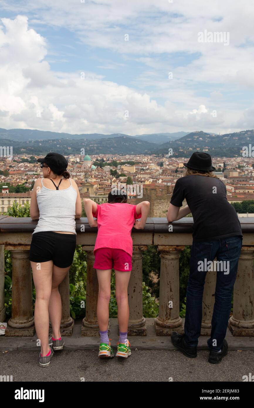 Die Familie lehnt sich über ein Geländer mit Blick über die Dächer von Florenz. Stockfoto