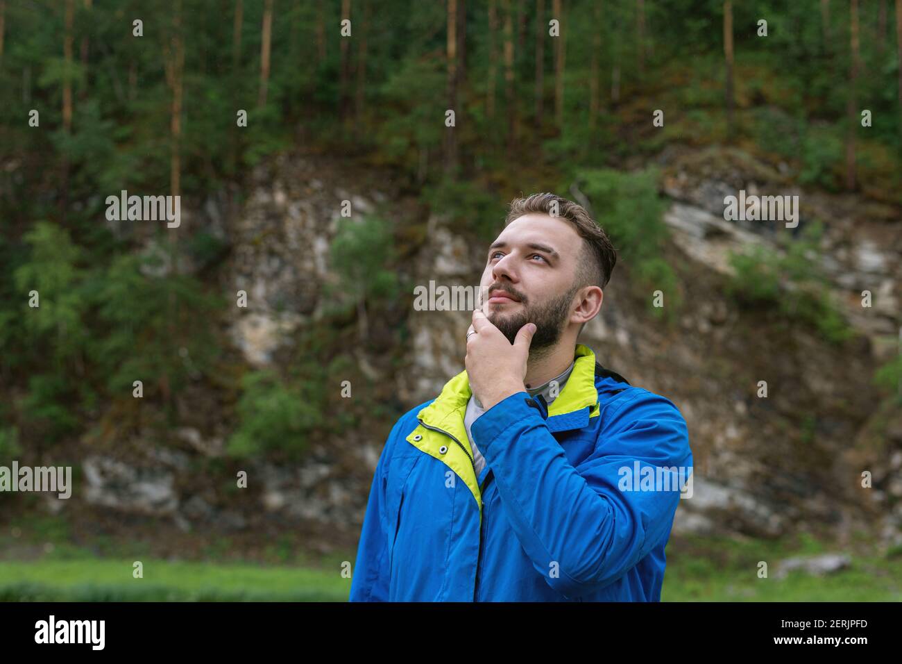 Porträt eines hübschen jungen bärtigen Mannes, der nachdenklich in den Himmel schaut. Lösung des Problems. Auf der Suche nach Inspiration. Kreative Persönlichkeit. Stockfoto