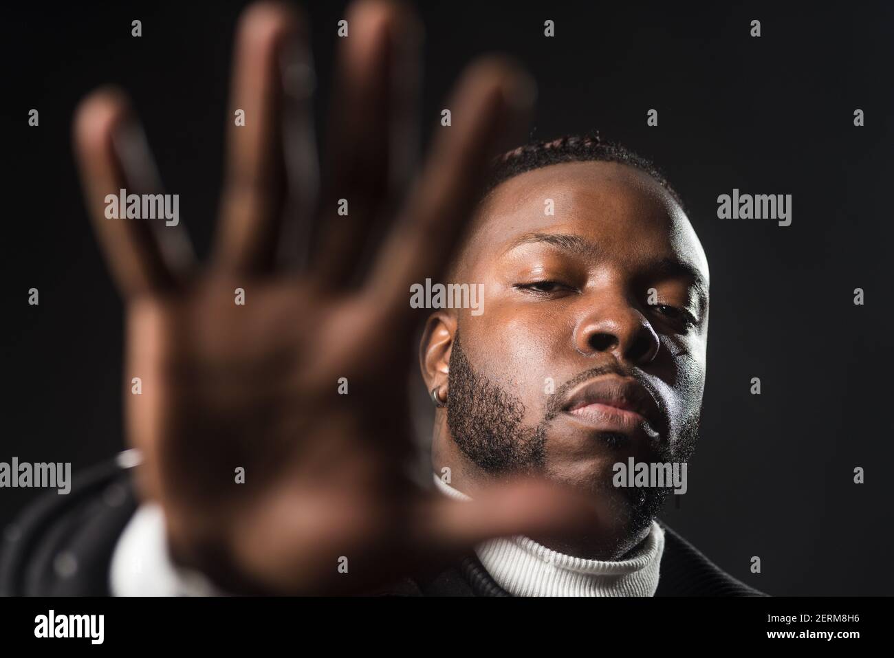 Ernsthafter schwarzer Mann, der Euch sagt, dass Ihr mit einer offenen Hand aufhören müsst. Stockfoto