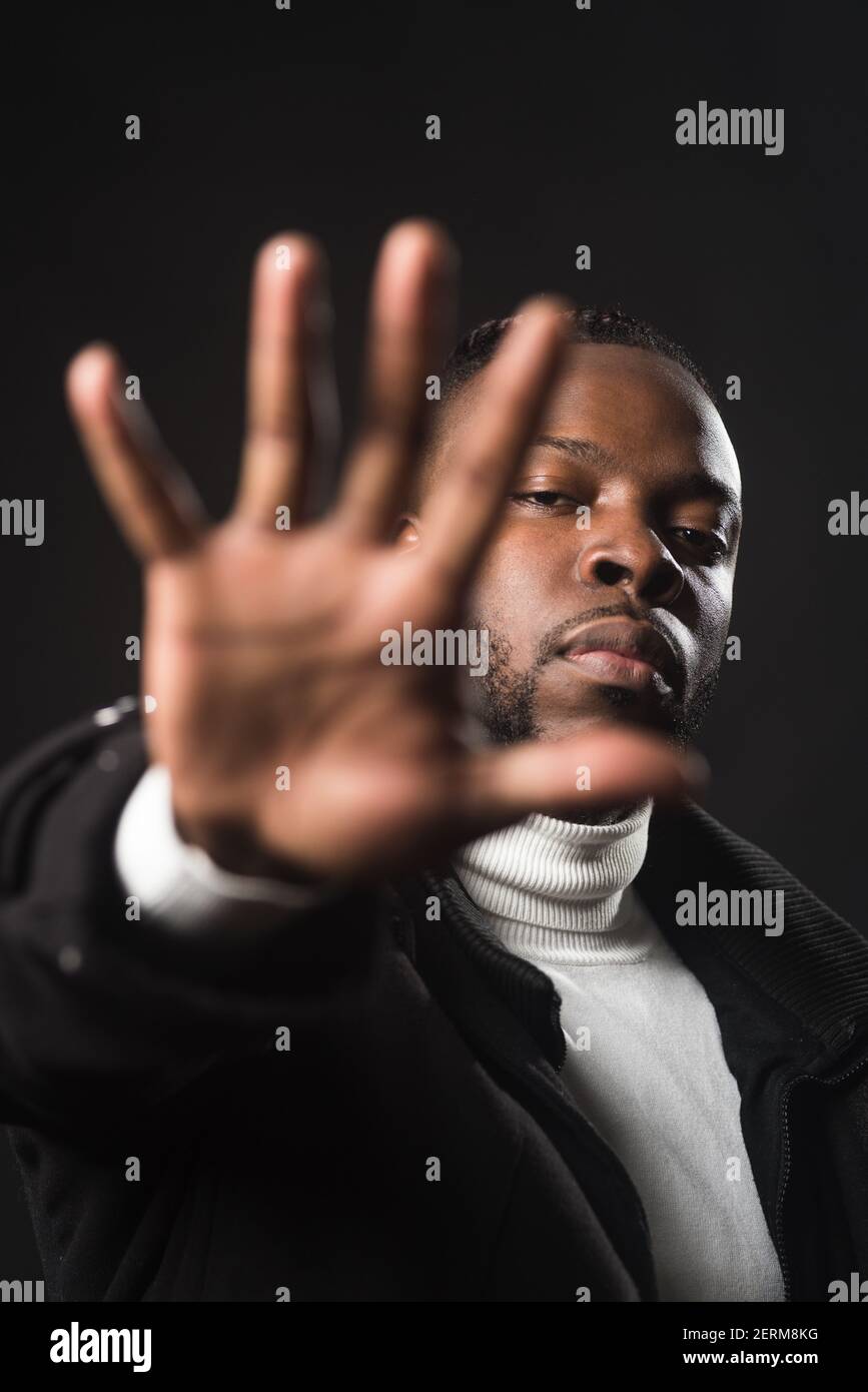 Ernsthafter schwarzer Mann, der Euch sagt, dass Ihr mit einer offenen Hand aufhören müsst. Stockfoto