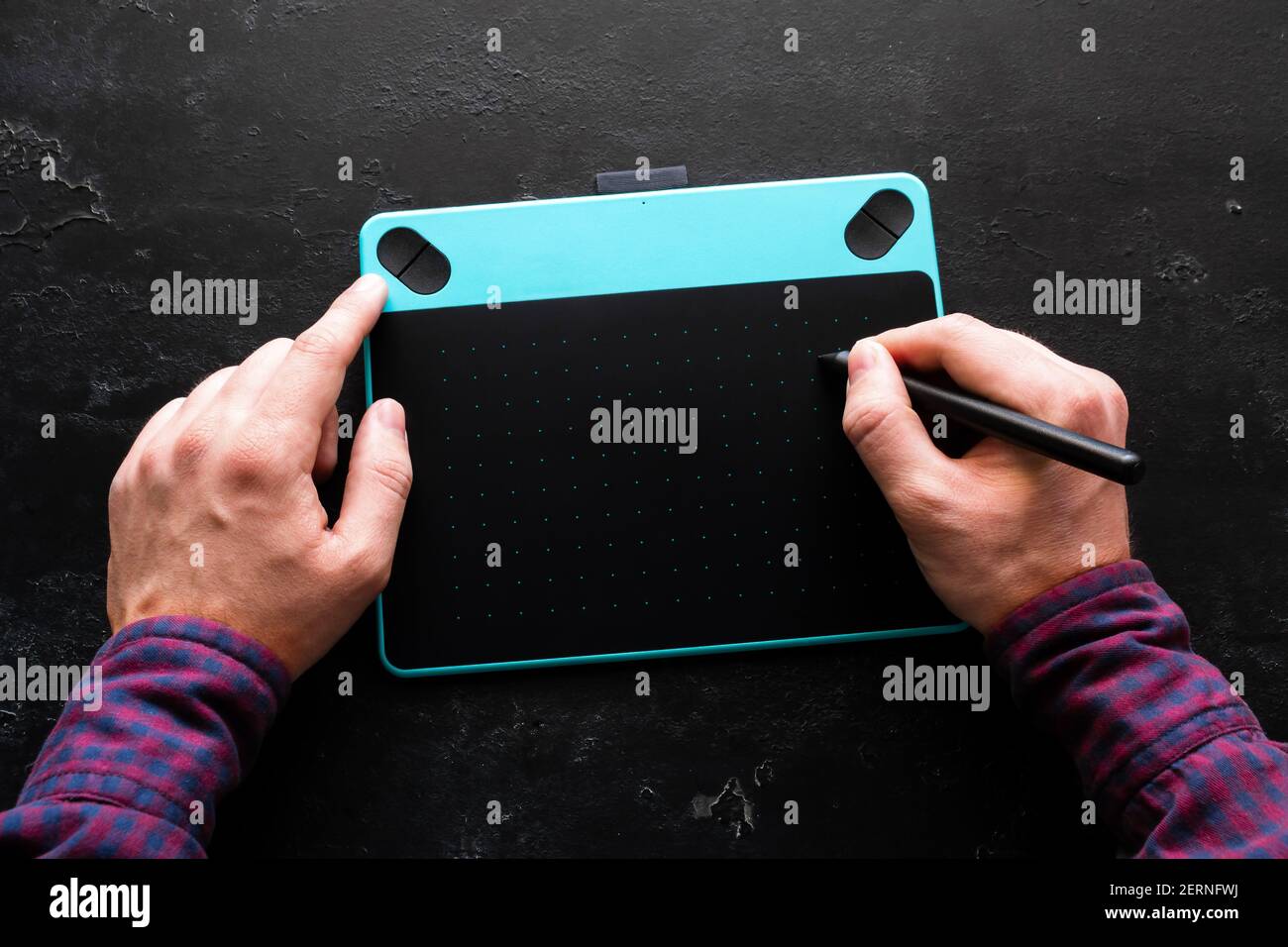 Mann zeichnet auf Grafik-Tablet auf schwarzem Hintergrund Stockfoto