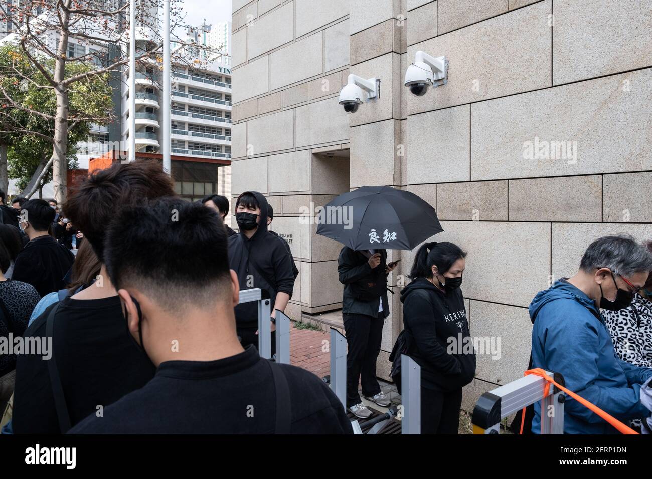 Vor dem West Kowloon Court stehen Anhänger von Demokratieaktivisten. 47 prodemokratische Aktivisten Hongkongs, die wegen Verschwörung zur Unterwanderung der Staatsmacht nach dem nationalen Sicherheitsgesetz angeklagt sind, nehmen an ihrer ersten Gerichtsverhandlung Teil, während sich Tausende von Unterstützern vor dem Gericht versammeln, um ihre Solidarität auszudrücken. Stockfoto