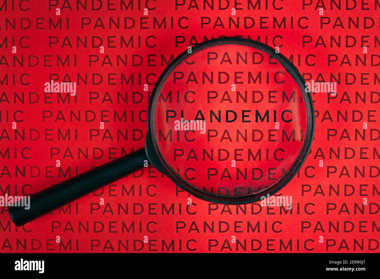 Lupe über Wort „Plandemic“ zwischen Zeilen wird Wort „Pandemic“. Konzept für Verschwörungstheorien während der Corona-Virus-Krise Stockfoto