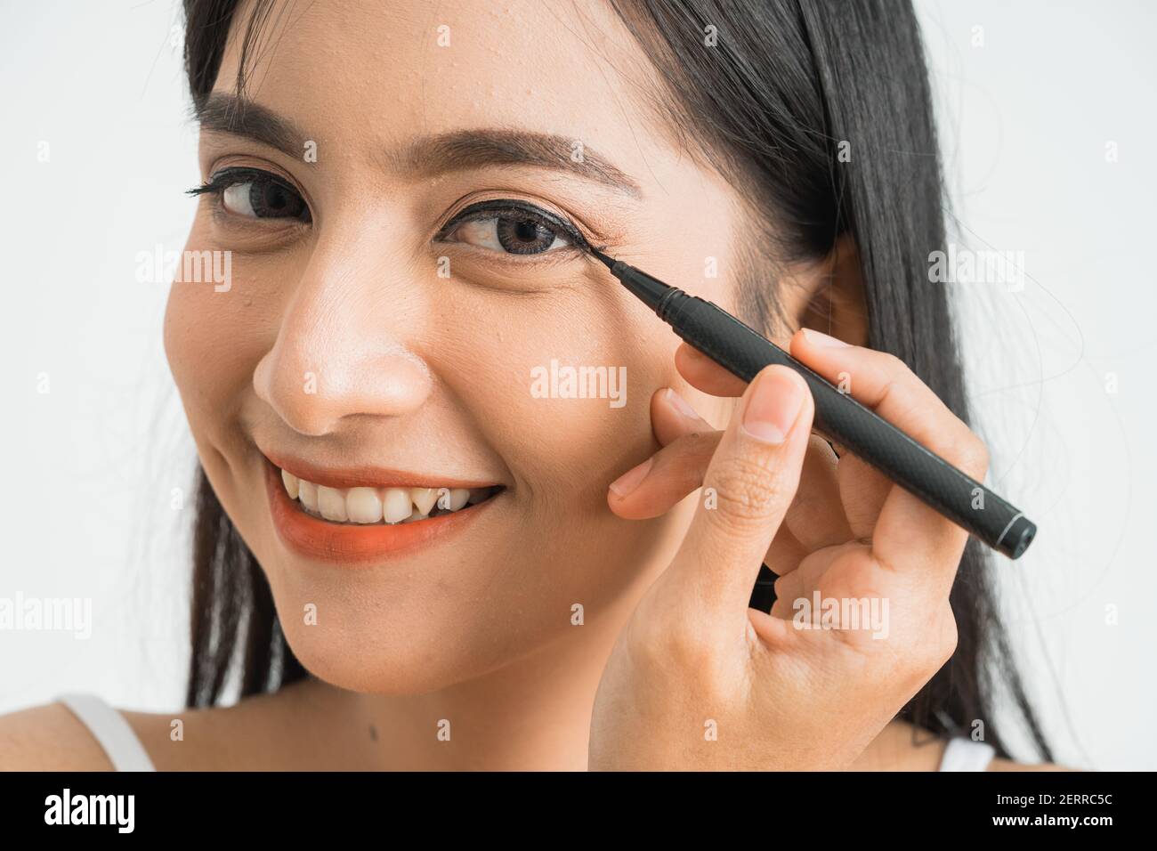 Gemischte Rasse asiatische Frau setzen Augenliner auf Augenlid auf Weißer Hintergrund Stockfoto