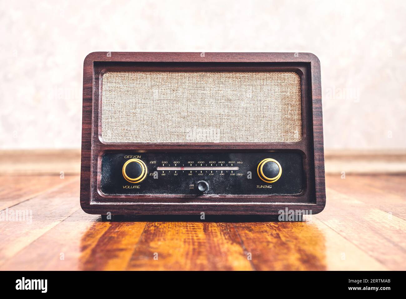 Retro-Radio im Vintage-Stil. Musik Nostalgie mit alten 60s Stil Song-Player. Staubiger Lautsprecher und Empfänger auf Holz. Drehknöpfe und Frequenztuner, Vorderansicht. Stockfoto