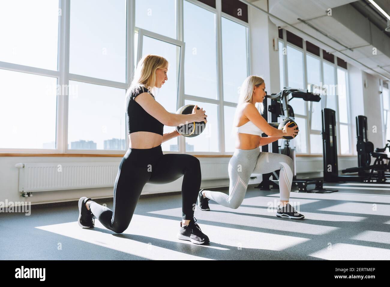 Zwei Fittige Frauen Machen Kniebeugen Mit Medizinball In Der Leichten Turnhalle An Sonnigen Tag Crossfit Gewichtsverlust Personliches Training Stockfotografie Alamy