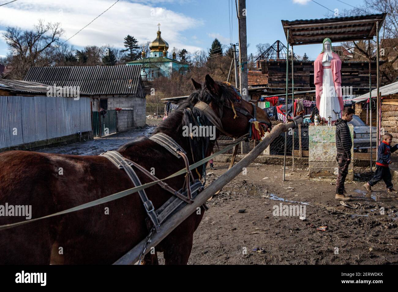 Welykyi Beresnyi, Ukraine. Februar 2021, 28th. VELYKYI BEREZNYI, UKRAINE - 28. FEBRUAR 2021 - EIN Pferd steht in der Nähe der Statue der Jungfrau Maria im Lager Romani, Velykyi Bereznyi Stadt-Typ Siedlung, Region Zakarpattia, Westukraine. Kredit: Ukrinform/Alamy Live Nachrichten Stockfoto