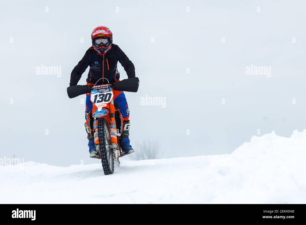 Russland Vyborg 02.23.2021 auf einem roten Motorrad-Rennfahrer fährt durch Der Schnee außerhalb der Stadt Stockfoto