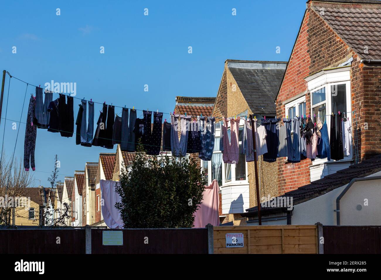 Eine Reihe von Gärten und Reihenhäuser mit einer Waschmaschine Linie mit der Kleidung hängen von ihm trocknend sie Stockfoto