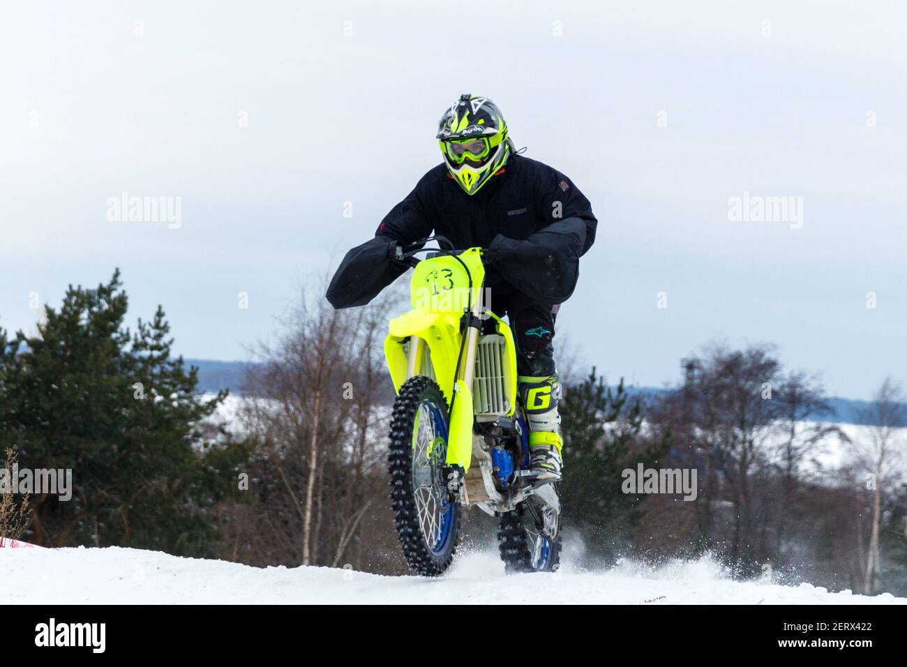 Russland Vyborg 02.23.2021 Motorradfahrer auf einem gelben Motorrad rauscht durch Der Schnee außerhalb der Stadt Stockfoto