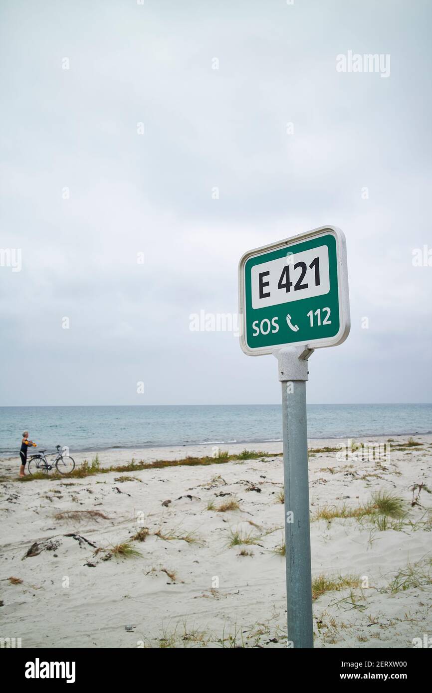 Ein grünes Hilferschild am Strand Stockfoto