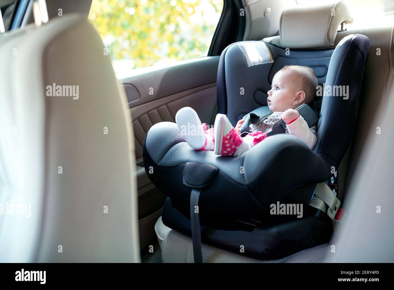 Neugieriges Baby genießen jeden Moment der Fahrt während des Sitzens In der Rückseite eines Fahrzeugs Stockfoto
