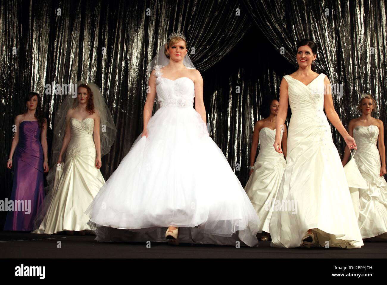 Models tragen Brautkleider und Kopfbedeckungen bei einer Brautmode Anzeigen Stockfoto
