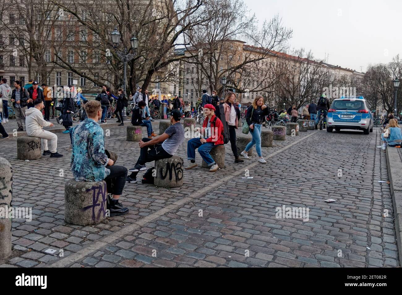 Junge Leute auf der Admiralsbrücke in Kreuzberg, Berlin , Vorfruehling, Lockdown, Polizeikontrolle der Abstandsregeln im Corona-Lockdown Februar 2021 Stockfoto