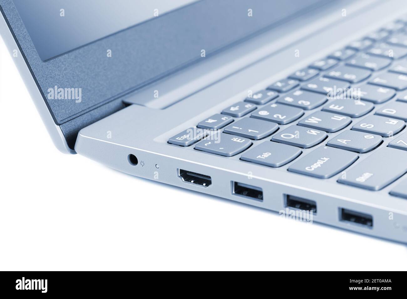 Ecke des Laptops auf weißem Hintergrund Nahaufnahme, grau-blau getönt Stockfoto