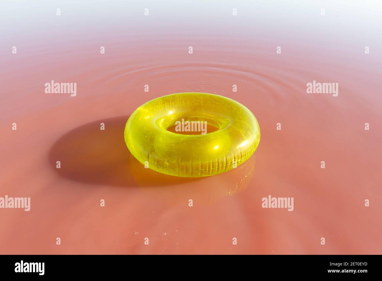 Leuchtend gelbe aufblasbare Ring schweben in rosa Wasser See. Kreativer Farbhintergrund Stockfoto