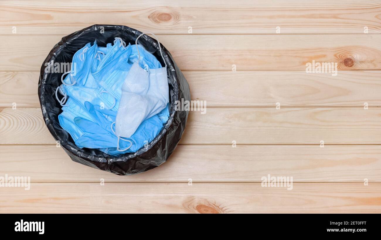 Müllkorb mit Masken Müll Covid 19. Einwegmasken in der oberen Ansicht des Bürobehälters. Werfen Sie weg Maske in Müll nach Pandemie Ende kovid Abfall Stockfoto