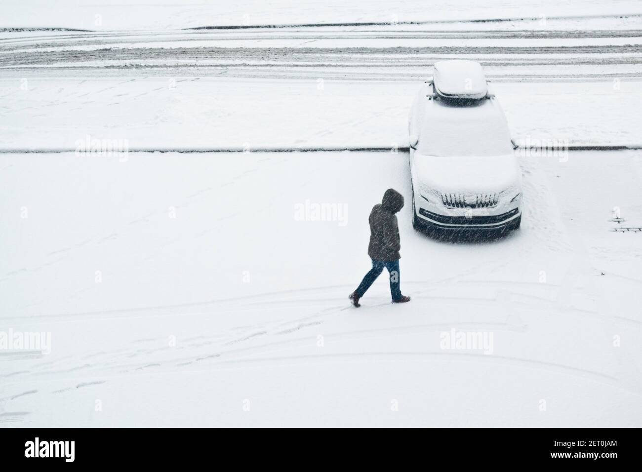 Auto mit Schnee bedeckt und eine Person, die während Ein Schneefall Stockfoto