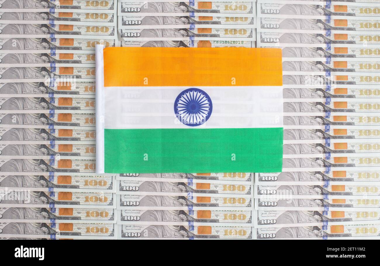 Indien Flagge auf einem Hintergrund von Dollar-Banknoten. Konzept des Verhältnisses des indischen Geldes in Bezug auf den Dollar, die Wirtschaft des Landes, in Stockfoto