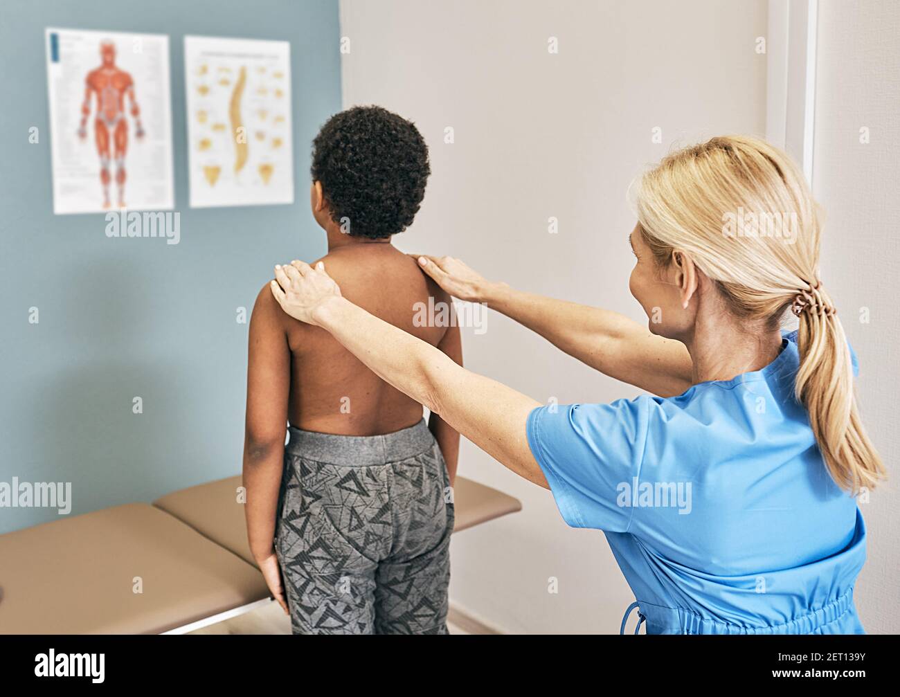 Osteopath untersucht die Wirbelsäule bei einem männlichen Kind. Medizinische Untersuchung, Skoliose, Kyphose bei einem Kind Stockfoto