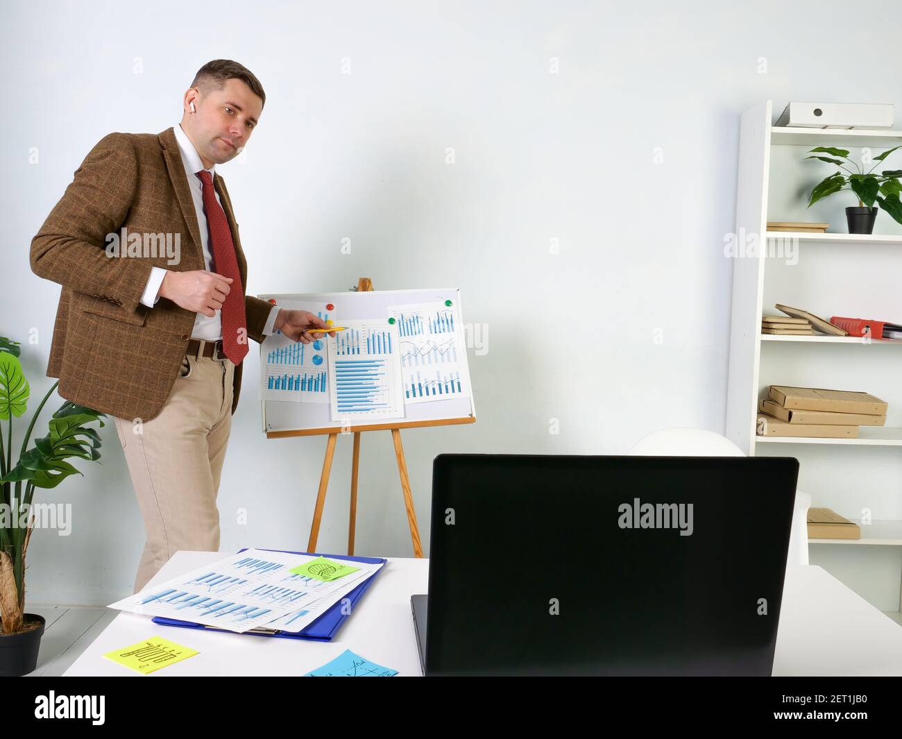 Ein Mann in einem Anzug macht eine Online-Präsentation mit Laptop. Stockfoto
