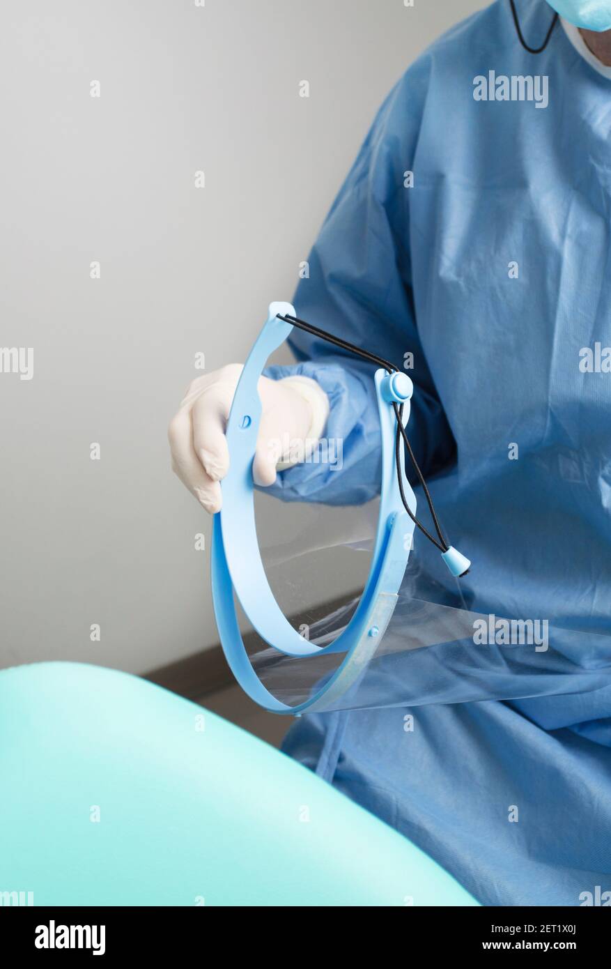 Zahnarzt mit Gesichtsschutz in den Händen, mit Patientenstuhl,  detaillierter Plan Stockfotografie - Alamy