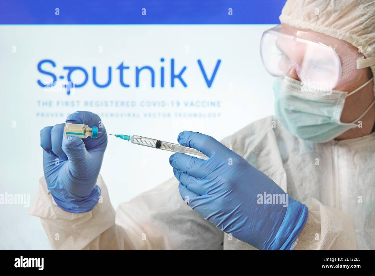 Ein Arzt bereitet einen Impfstoff gegen das Coronavirus covid 19 auf dem Hintergrund des Sputnik V-Logos vor. 18. Januar 2021, Barnaul, Russland. Stockfoto