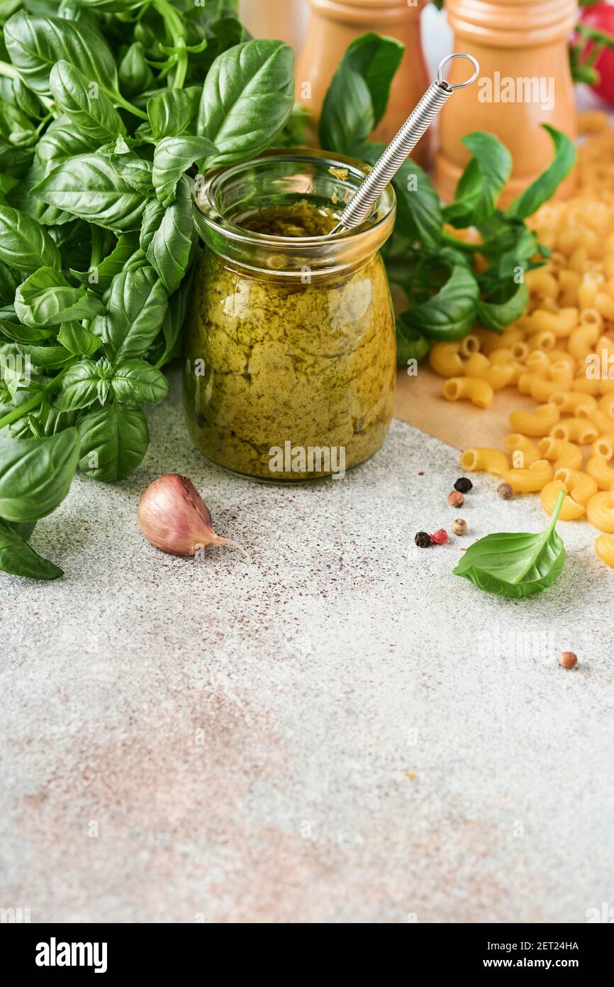 Chifferi rigati klassische rohe Pasta in braunem Papier auf hellem Holztischhintergrund mit Basilikum und Öl. Stockfoto